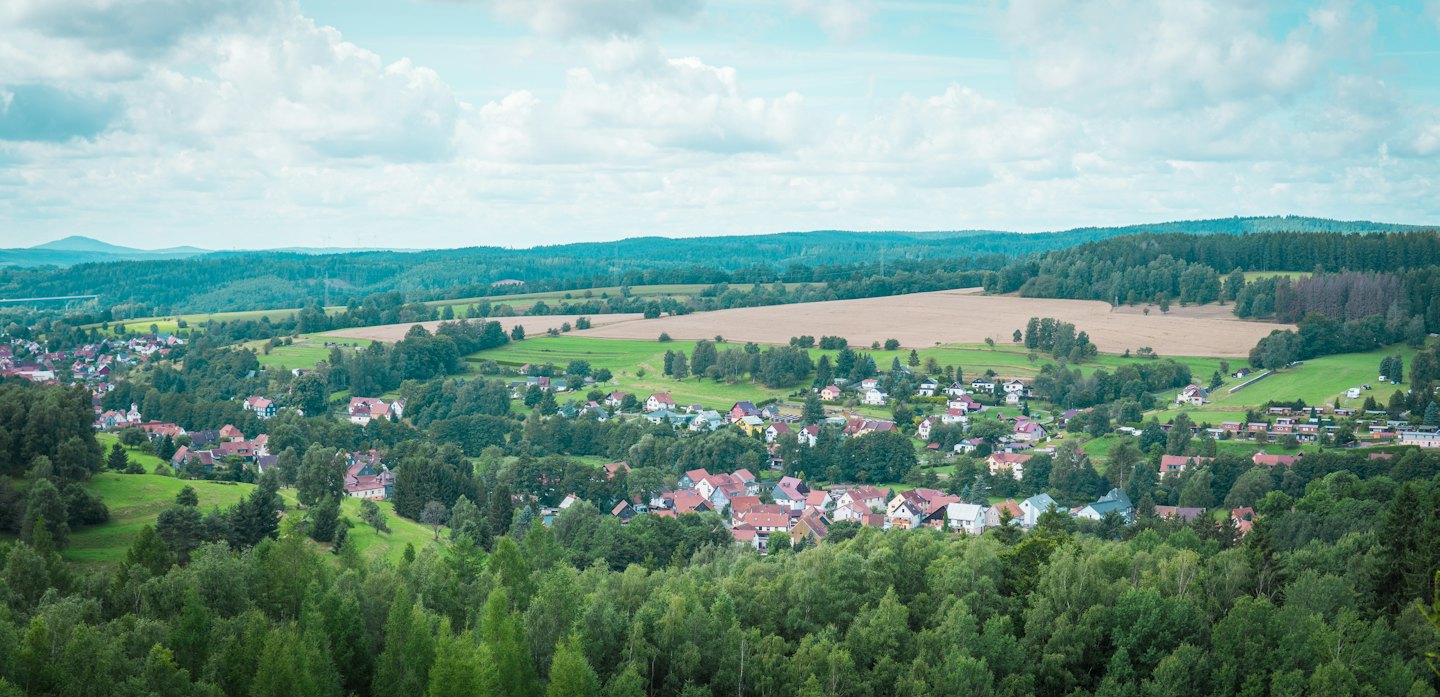 Un village niché au milieu de forêts verdoyantes et de collines.