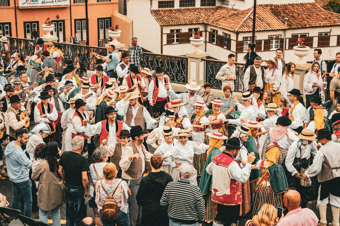 Une foule de festival de rue en costumes folkloriques avec des instruments à cordes et de la danse.