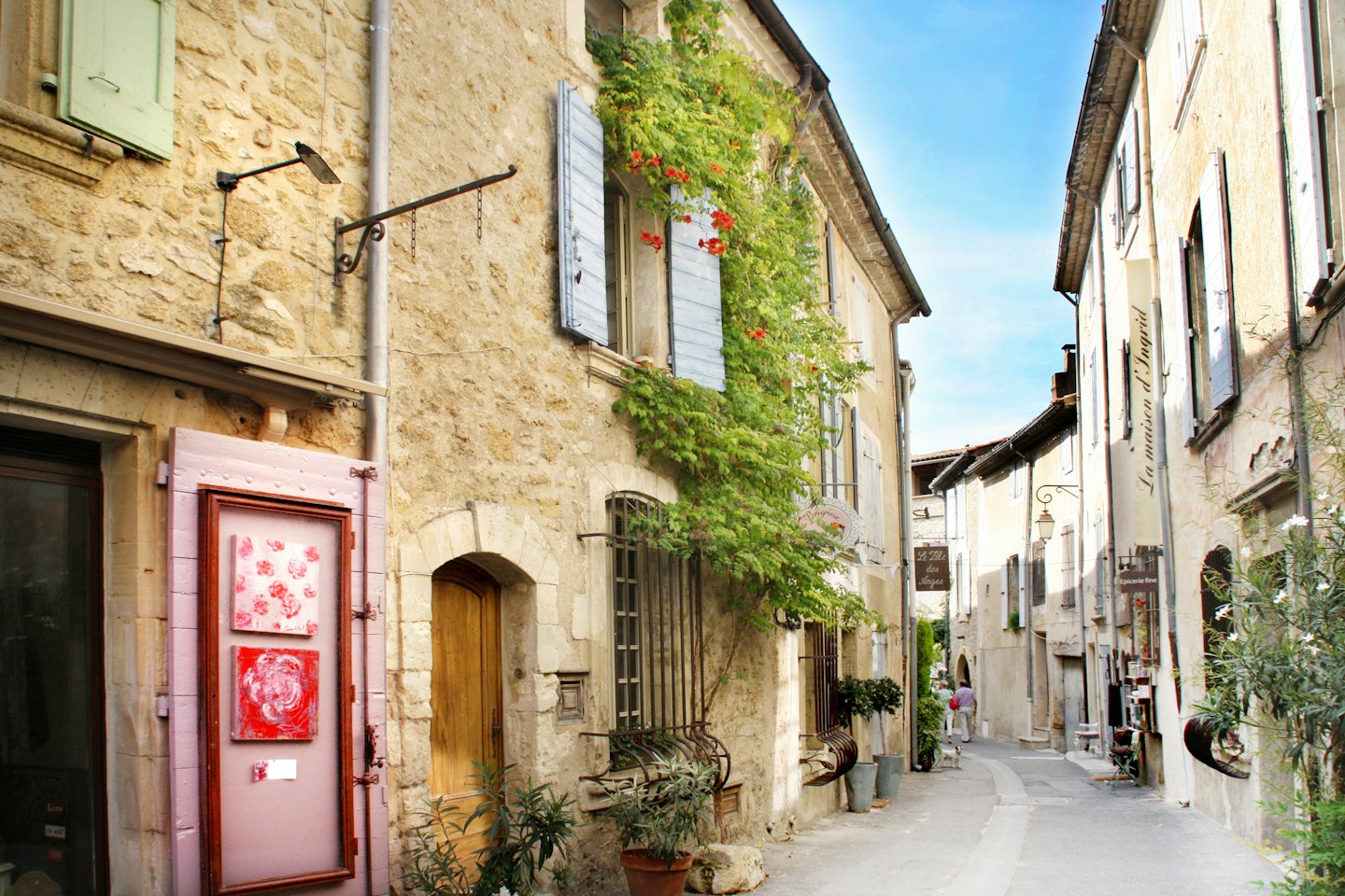 Une personne descend une ruelle pavée étroite en France.
