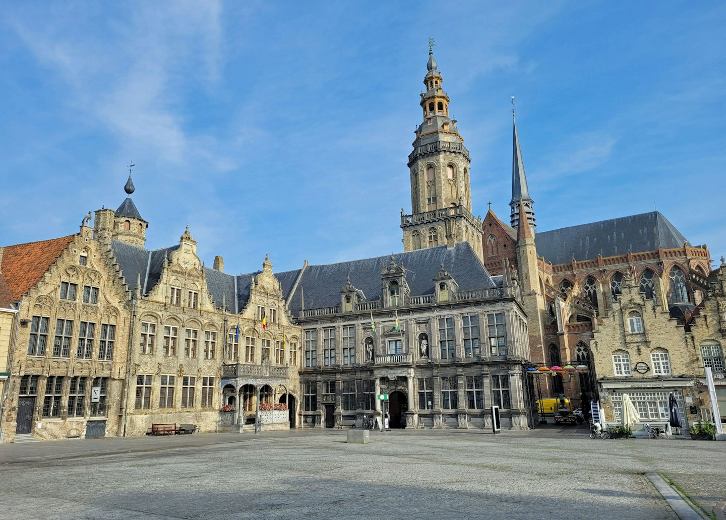 Des bâtiments historiques et un clocher surplombent une place pavée.